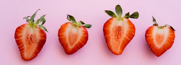 Tendido plano de fresas en rodajas rojas en fila aislado en rosa con espacio para copiar, pancarta - foto de stock