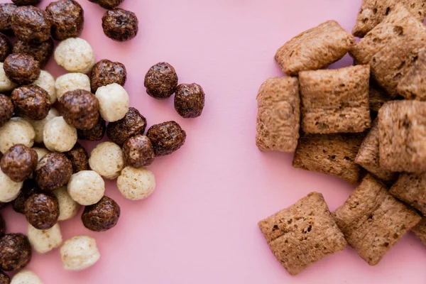 Vista superior de varias bolitas de cereales de desayuno y bolas aisladas en rosa - foto de stock