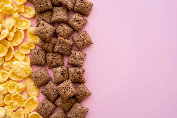 Disposición plana de desayuno bollos de cereales y copos de maíz crujientes aislados en rosa - foto de stock