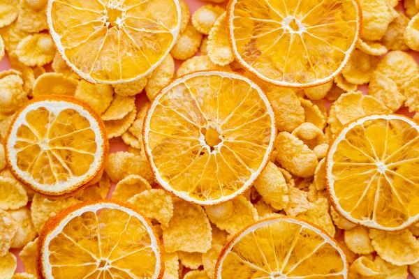 Top view of dried oranges on top of crispy breakfast corn flakes — Stock Photo