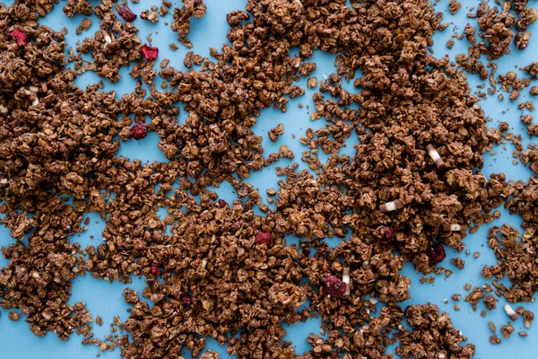 Top view of crunchy granola with dry red berry on blue background — Stock Photo