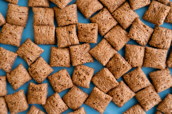 Top view of chocolate cereal puffs on blue background — Stock Photo