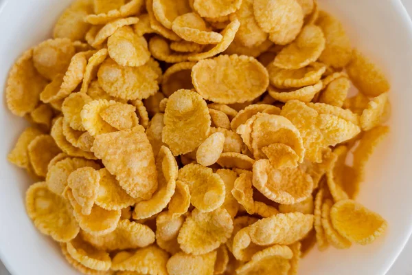 Close up view of bowl with crispy yellow corn flakes — Stock Photo