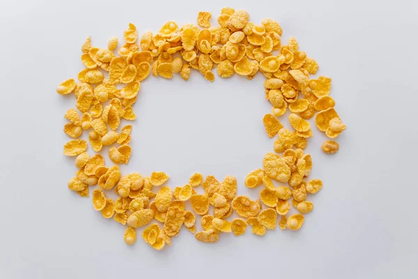 Top view of dry and crispy corn flakes in shape of circle isolated on white — Stock Photo