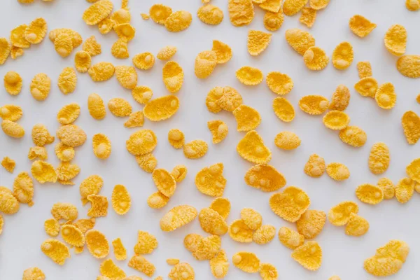 Top view of crispy and yellow corn flakes on white background — Stock Photo