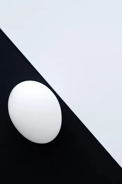 Top view of chicken egg on white and black background — Stock Photo