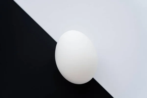 Top view of organic chicken egg on white and black background — Stock Photo