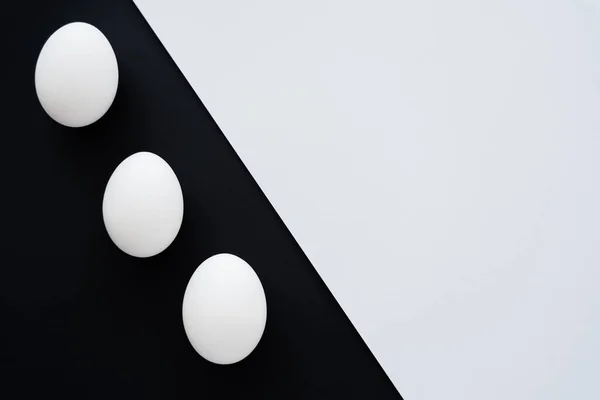 Top view of natural chicken eggs on white and black background — Stock Photo