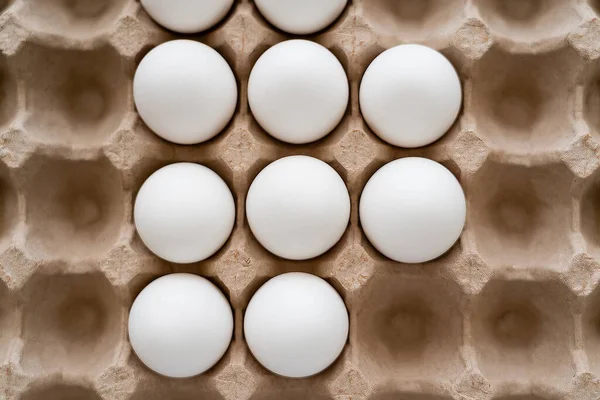 Vista superior de ovos de galinha branca em recipiente de papelão — Fotografia de Stock