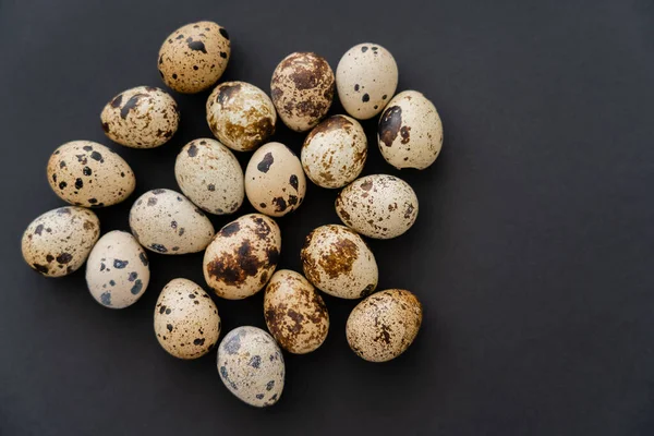 Vista superior de ovos de codorna naturais na superfície preta — Fotografia de Stock
