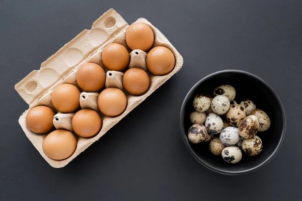 Vista superior de ovos de galinha e codorniz naturais sobre fundo preto — Fotografia de Stock