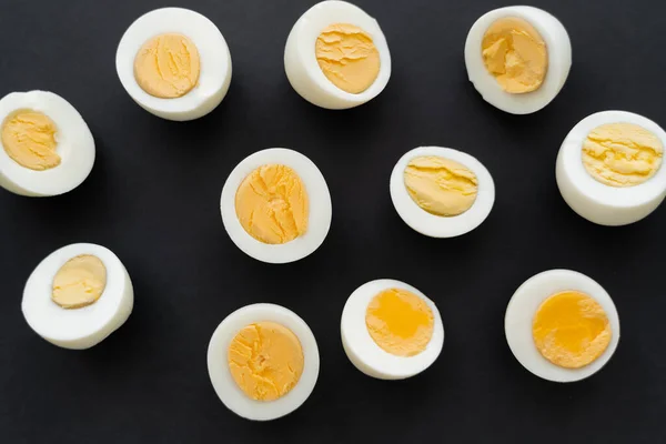 Top view of organic boiled eggs on black background — Stock Photo