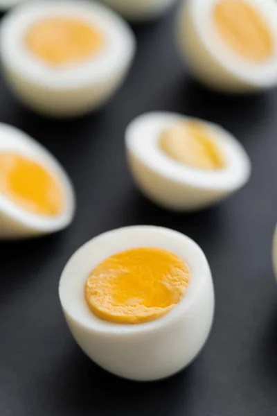 Close up view of cut boiled chicken egg on black background — Stock Photo