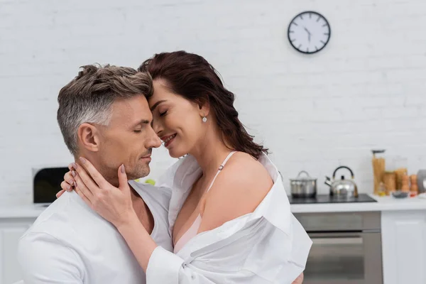 Sexy mujer en camisa besar y tocar marido en cocina - foto de stock