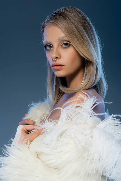 Jeune femme blonde avec de la neige sur les cheveux et des sourcils blancs sur bleu foncé — Photo de stock