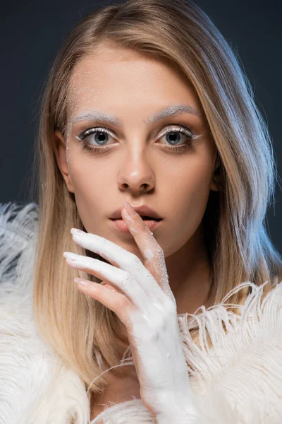 Porträt einer blonden jungen Frau mit winterlichem Make-up, die isoliert auf dunkelblau posiert — Stockfoto