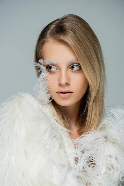 Retrato de mujer bonita con maquillaje de invierno y cejas blancas mirando hacia otro lado aislado en gris - foto de stock