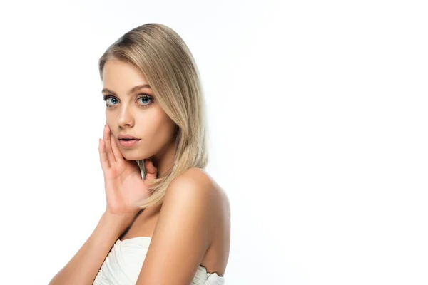 Blonde model with bare shoulders and blue eyes looking at camera isolated on white — Stock Photo