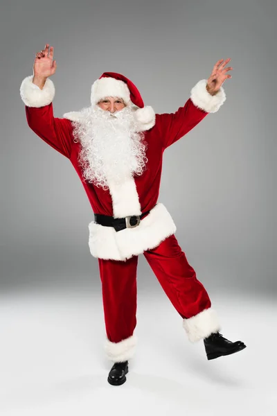 Full length of santa claus in costume dancing on grey background — Stock Photo