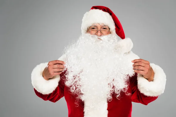 Santa Claude en lunettes et chapeau regardant caméra isolée sur gris — Photo de stock