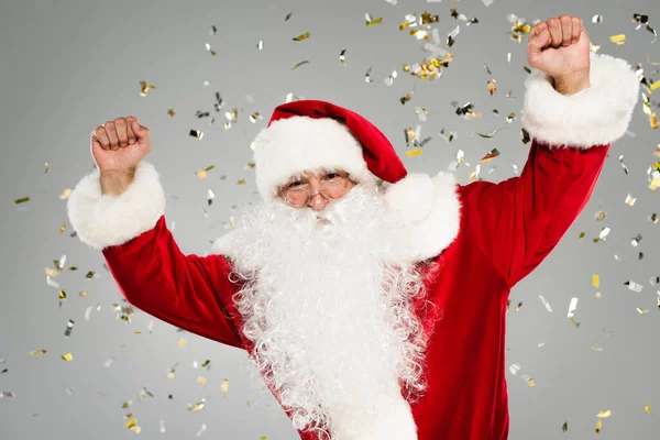 Emocionado pai natal mostrando sim gesto sob confete em fundo cinza — Fotografia de Stock