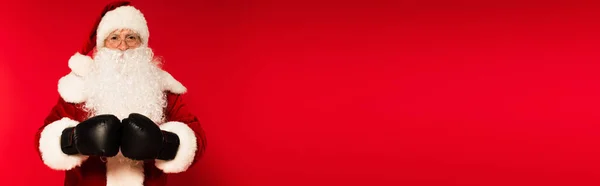 Father christmas in costume and boxing gloves on red background with copy space, banner — Stock Photo