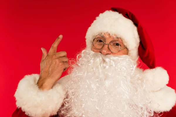 Portrait du Père Noël barbu pointant avec le doigt isolé sur le rouge — Photo de stock