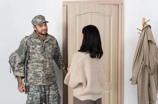 Mulher morena reunião sorrindo marido raspado em uniforme militar voltando para casa — Fotografia de Stock