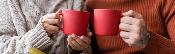 Partial view of couple holding cups with traditional christmas cocoa, banner — Stock Photo