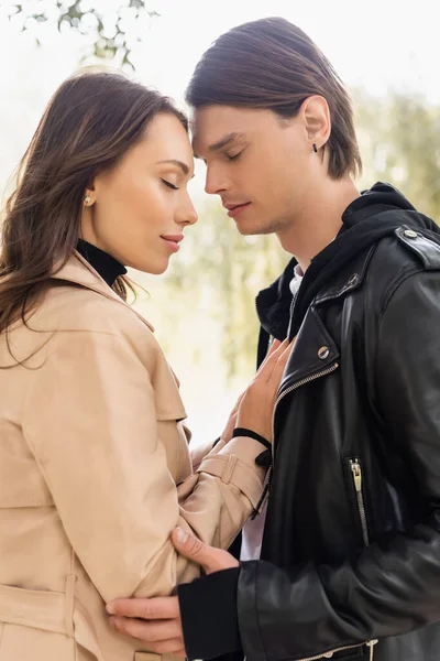 Side view of sensual young woman touching chest of man with closed eyes — Stock Photo