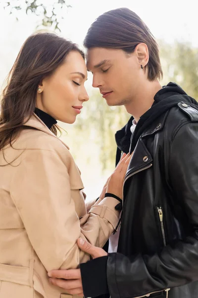 Seitenansicht einer sinnlichen jungen Frau, die die Brust eines Mannes mit geschlossenen Augen berührt — Stockfoto