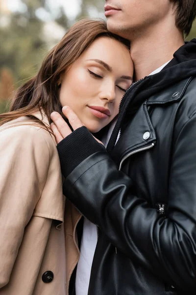 Pretty young woman with closed eyes leaning on chest of boyfriend — Stock Photo