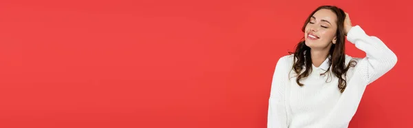 Красива брюнетка в теплому светрі закриває очі ізольовані на червоному, банер — Stock Photo