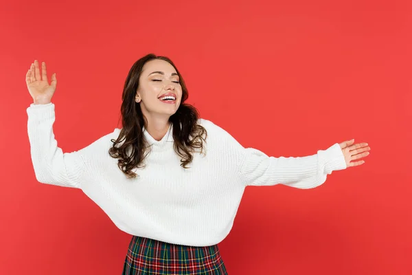 Cheerful young woman with closed eyes standing isolated on red — Stock Photo