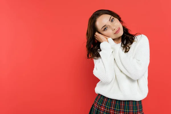 Giovane donna in maglione caldo guardando la fotocamera isolata sul rosso — Foto stock