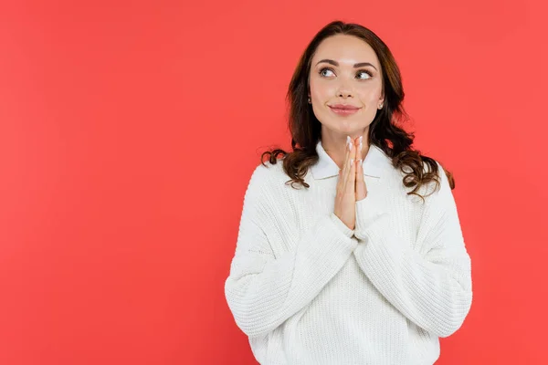 Mujer sonriente en saltador acogedor haciendo gesto de esperanza aislado en rojo — Stock Photo