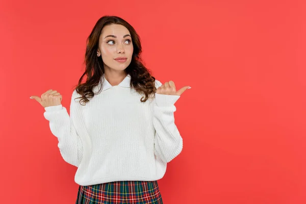 Pretty woman in white jumper pointing with fingers isolated on red — Stock Photo
