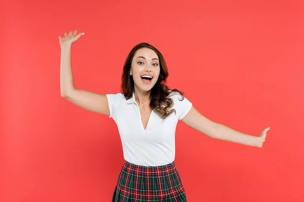Cheerful woman in white t-shirt looking at camera isolated on red — Stock Photo