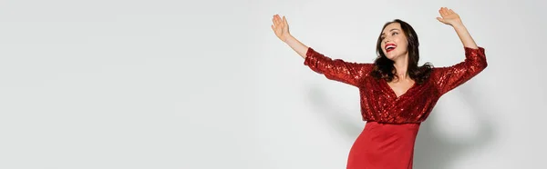 Mujer positiva en vestido elegante bailando sobre fondo gris, bandera - foto de stock