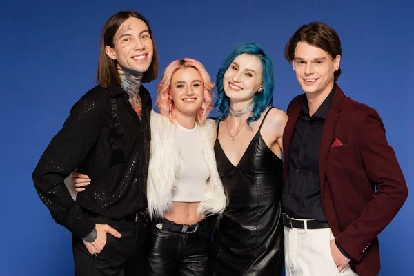 Happy queer friends in stylish clothes looking at camera isolated on blue — Stock Photo