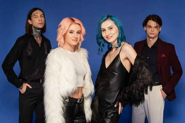 Nonbinary people in stylish clothes looking at camera while posing isolated on blue — Stock Photo