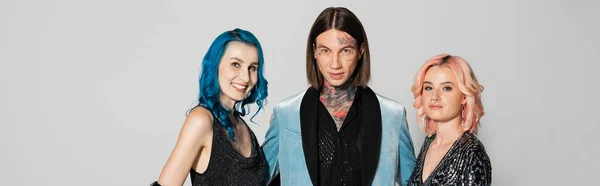 Tattooed queer person and nonbinary friends hair looking at camera isolated on grey, banner — Stock Photo