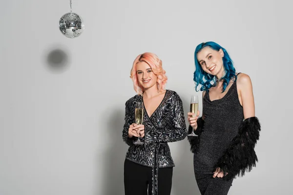 Elegant queer friends holding champagne glasses on grey background — Stock Photo