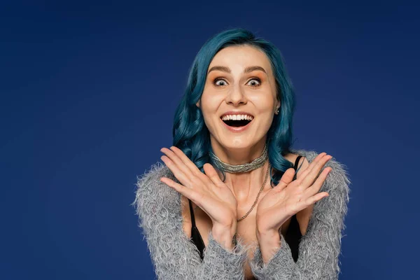 Erstaunt Frau mit gefärbten Haaren zeigt Wow-Geste und Blick in die Kamera isoliert auf blau — Stockfoto