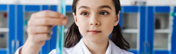 Preteen girl holding blurred test tube in chemical laboratory, banner — Foto stock