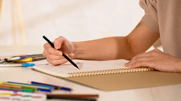 Vista cortada de mulher desenho em caderno de esboços em casa — Fotografia de Stock