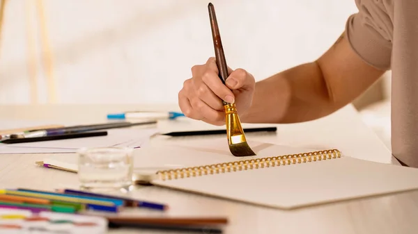 Vista recortada de la joven pintura en cuaderno de bocetos en casa - foto de stock