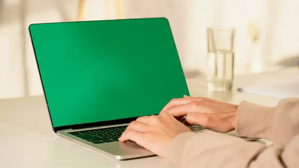 Vista cortada da mulher usando laptop com tela verde em casa — Fotografia de Stock