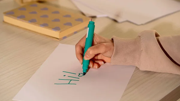 Vista ritagliata della donna con pennarello scritto su carta a casa — Foto stock