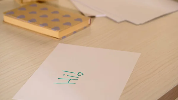 Salut lettrage sur papier près de notebook sur table en bois — Photo de stock
